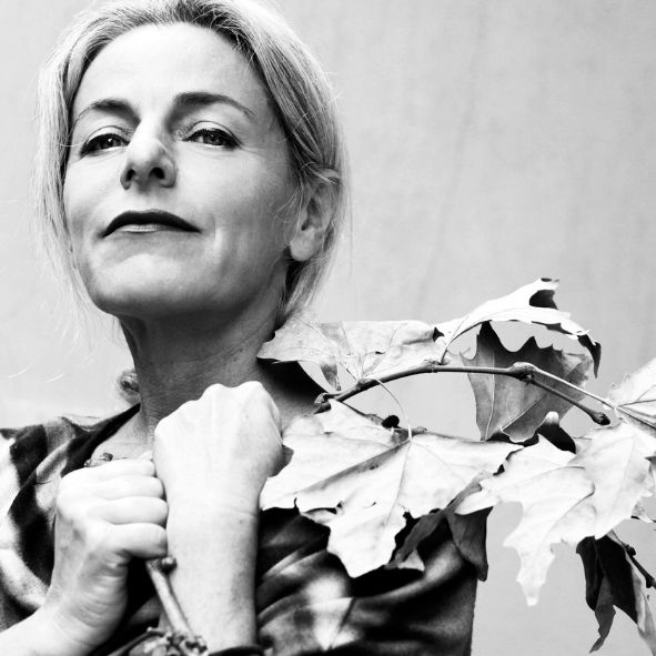primo piano di Lucilla Giagnoni con un ramo con foglie in mano