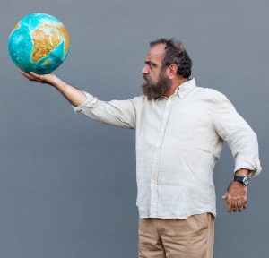 Giobbe Covatta che tiene in mano un mappamondo