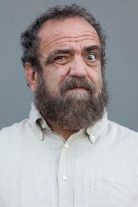 primo piano di Giobbe Covatta con la faccia perplessa