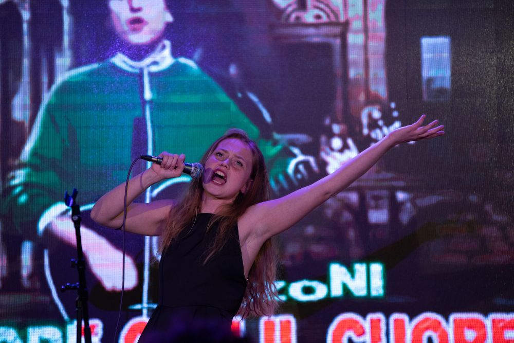 una givane donna che canta con in mano un microfono
